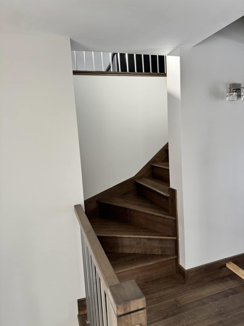Escalier tournant en bois foncé, vu du bas