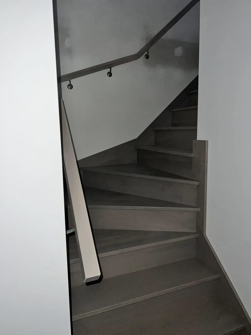 Escalier tournant peint gris avec main courante murale
