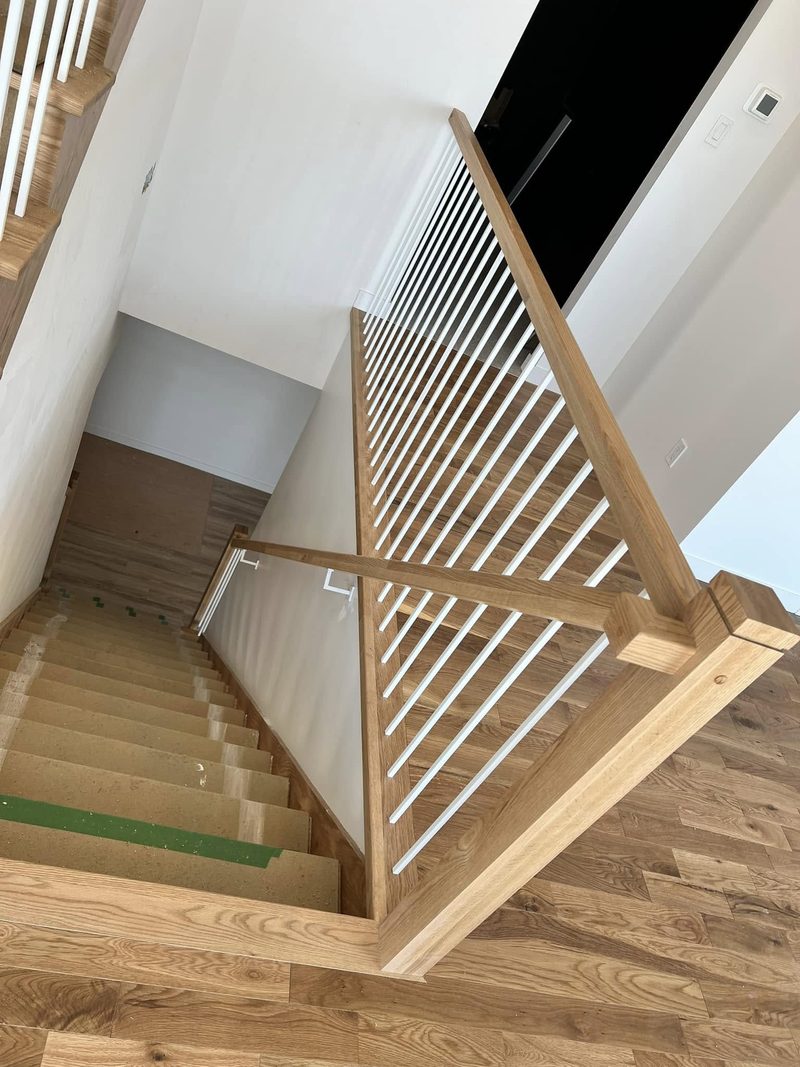Escalier en chêne avec garde-corps à barreaux de bois, vu de l'étage
