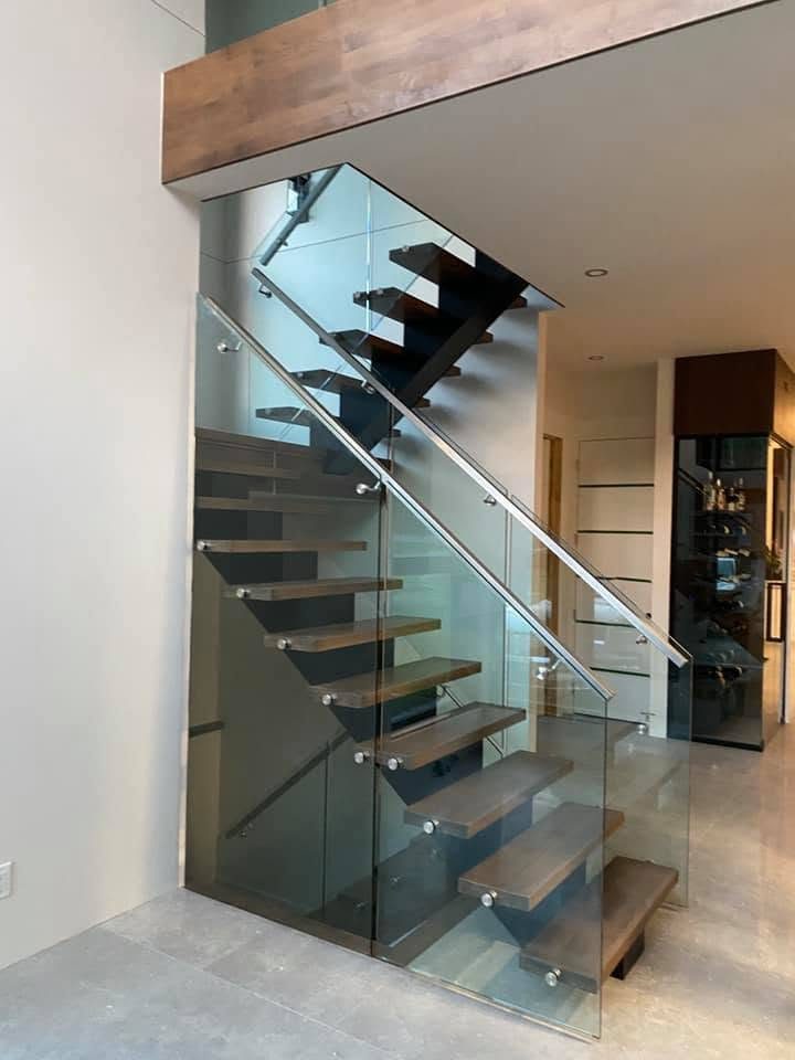 Escalier flottant avec garde-corps de verre trempé, vu sous la mezzanine